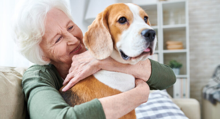 Ältere Frau umarmt einen grossen Hund